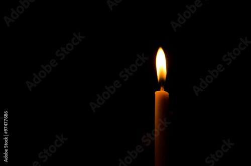 One frame light candle burning brightly in the black background