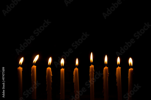 frame light candle burning brightly in the black background