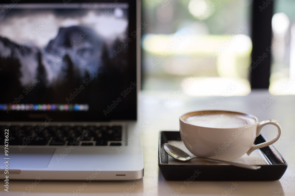 Hot art Latte Coffee in a cup and laptop on wooden table. Hot art Latte Coffee in a cup and laptop on wooden table.