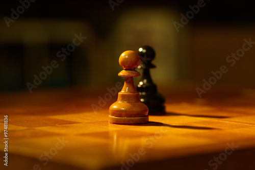 Chess. Chess on the chessboard. Two pawns. Confrontation. Winning the fight.