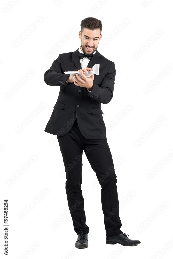 Furious man in suit crumpling contract paper with his hands. Full body length portrait isolated over white studio background. Furious man in suit crumpling contract paper with his hands. Full body length portrait isolated over white studio background.