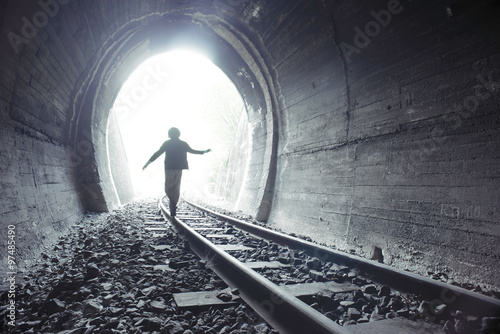 Child walking in railway tunnel photo