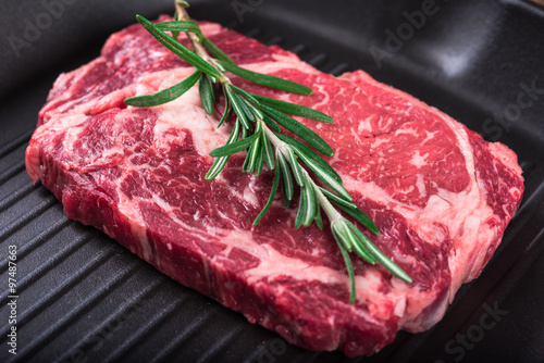 Photography Raw marbled meat steak Ribeye on grill pan on dark wooden background
