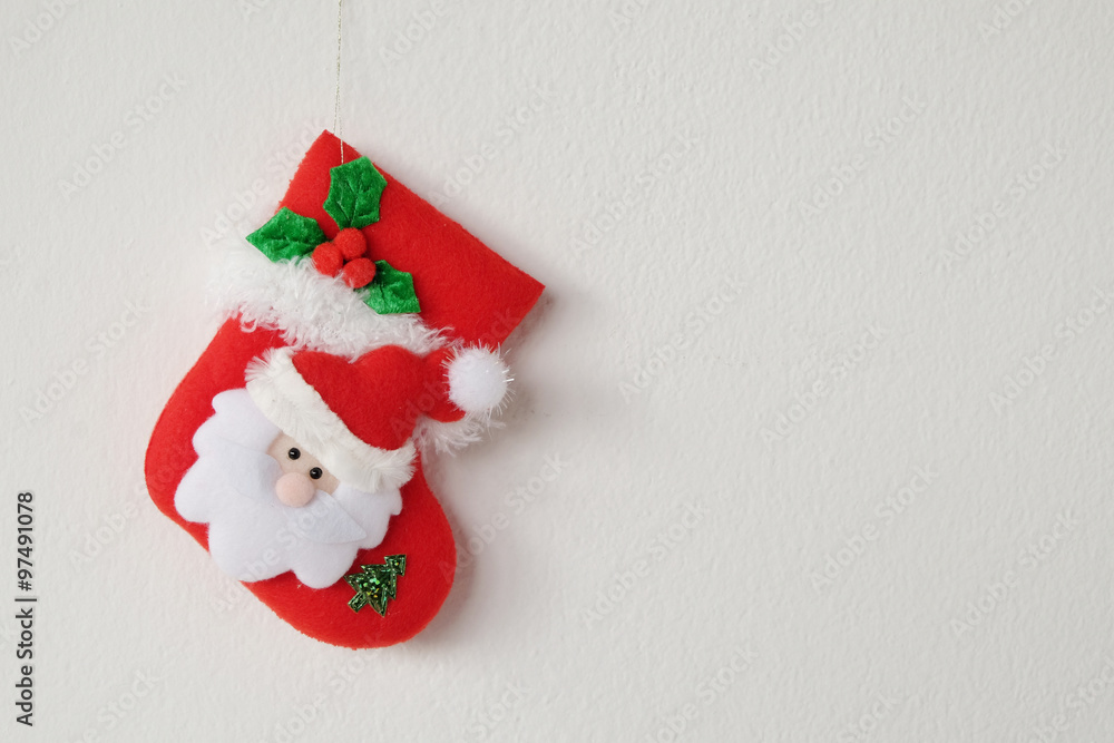 Red Christmas sock hanging on white wall background