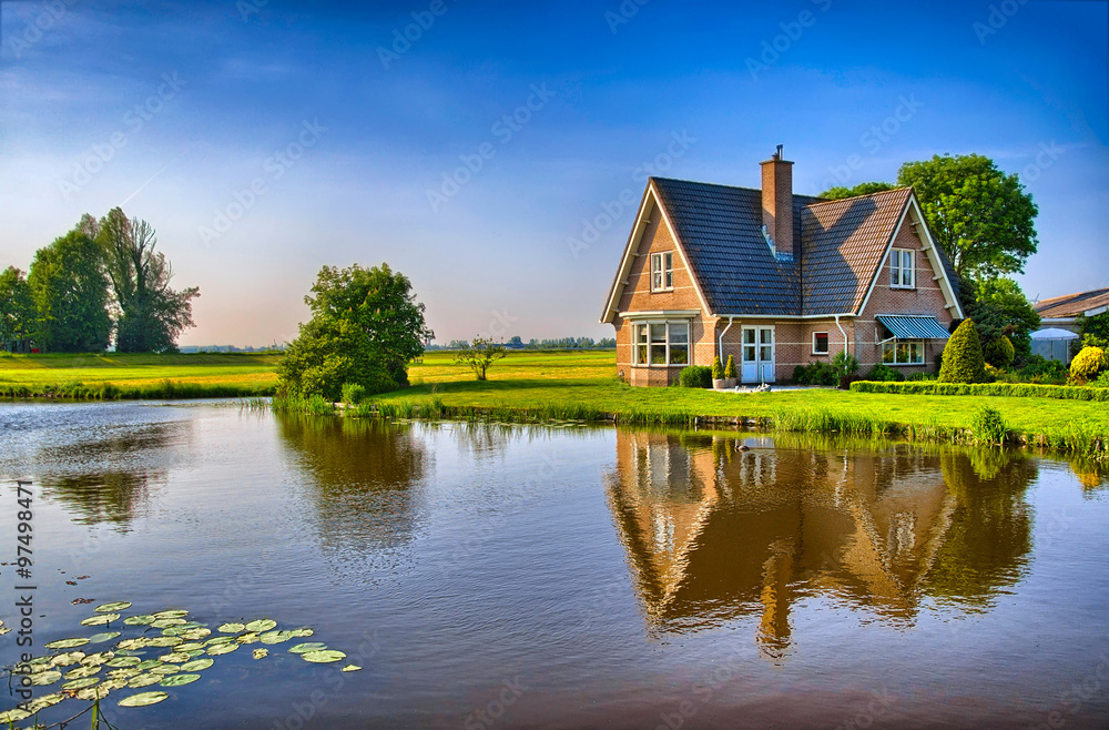 Red bricks house in countryside near the lake with mirror reflec - obrazy, fototapety, plakaty 