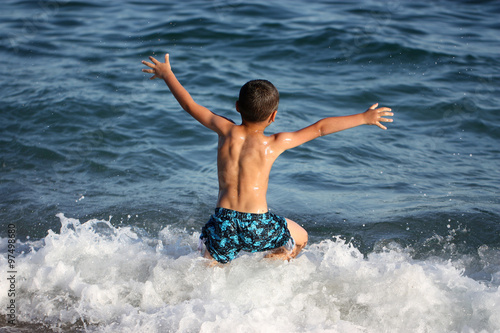 happy boy running in the sea © avanesovan
