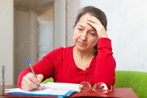 Sad mature woman with  bills