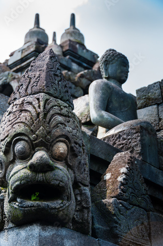 Big Eyed Sculpture and sitting stone Buddha at Borobudur temple
