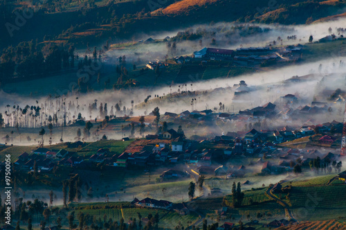 Thin Fog and mist surrounding a village next to volcano Bromo