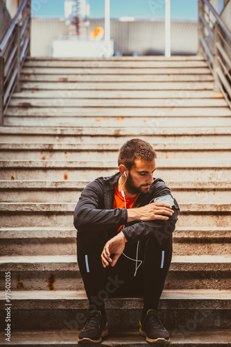 Young man resting on the stairs after running 