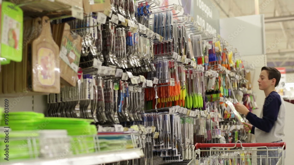 Teen boy in the store chooses knife Teen boy in the store chooses knife