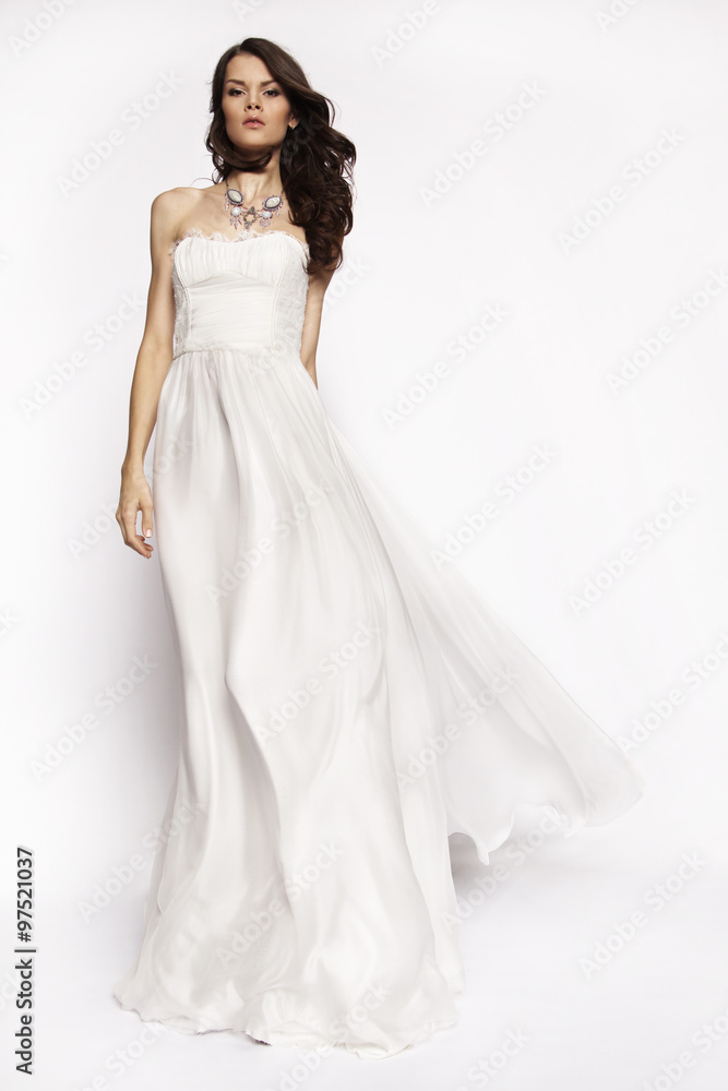 Brunette in white dress posing
