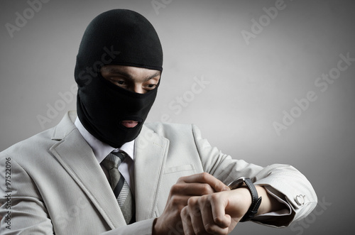 robber in a white tuxedo looks at the clock