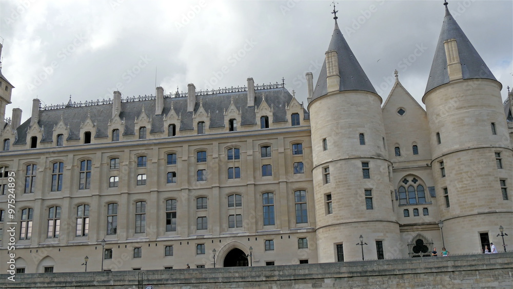 The very wide building found in the city of Paris. With lots of people walking in and out of the building The very wide building found in the city of Paris. With lots of people walking in and out of the building
