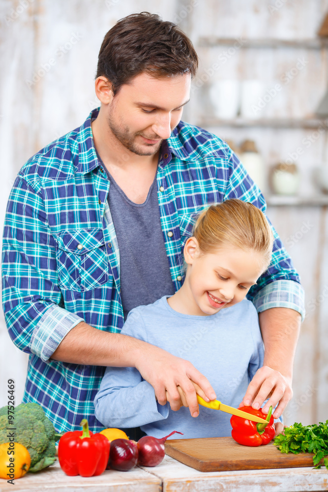 Happy father and daughter cooking together Happy father and daughter cooking together