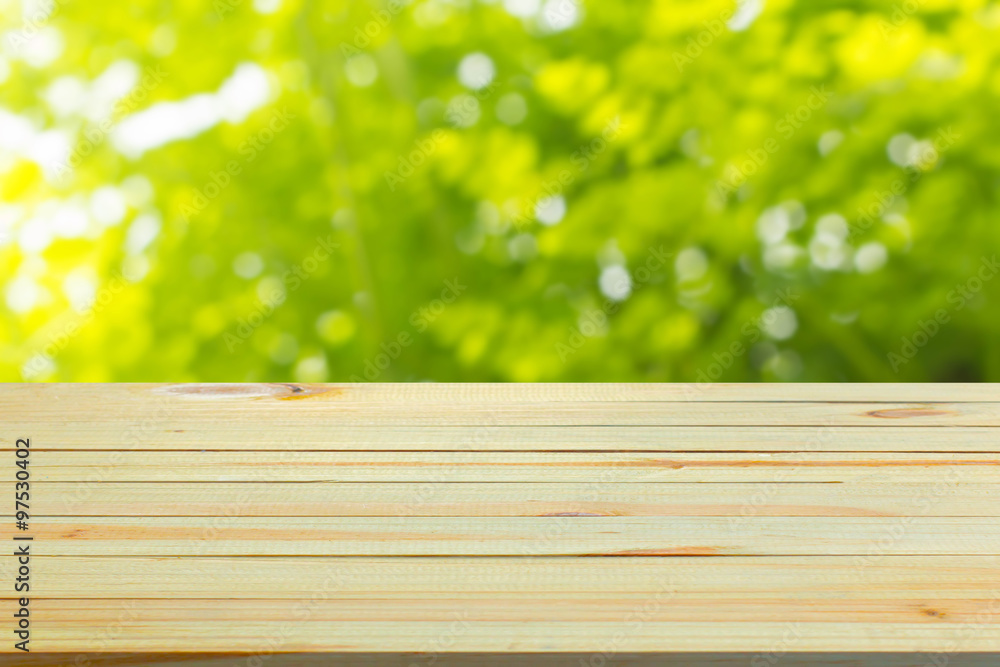 Close up top wooden table with sunny abstract green nature background, blurred bokeh Close up top wooden table with sunny abstract green nature background, blurred bokeh
