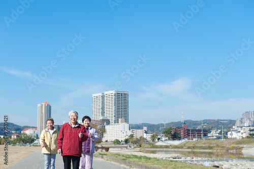 青空を背景に歩いている3人のアジア人高齢者