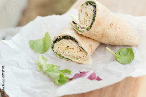 a healthy wrap with turkey, greens and cheese made with whole grain tortilla wrap