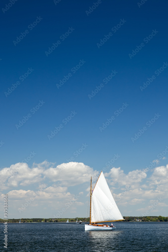 Fototapeta premium Single Sailboat as viewed on a beautiful Spring day from the Chesapeake Bay Maritime Museum in Saint Michael's, Maryland.