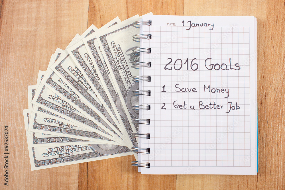 Naklejka premium New years resolutions written in notebook and currencies dollar