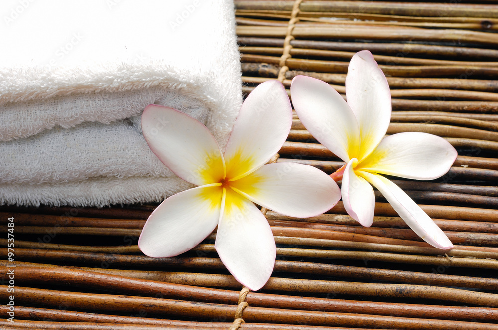 Set of frangipani flower with towel on mat Set of frangipani flower with towel on mat