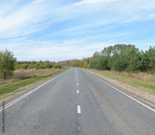 Suburban asphalt highway with white intermittent markings