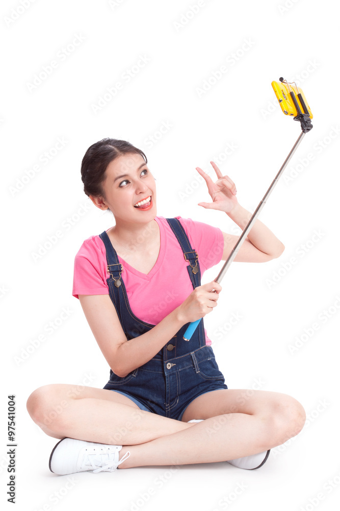 Happy woman taking picture with smartphone selfie stick Happy woman taking picture with smartphone selfie stick