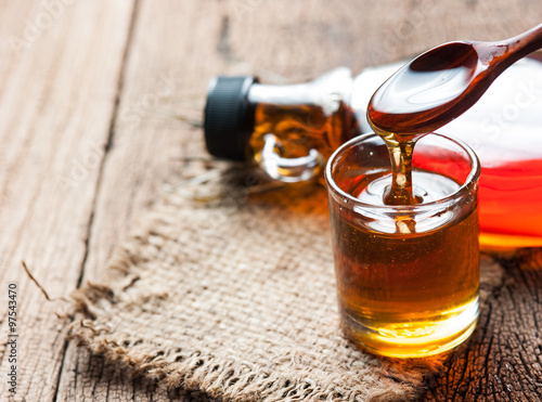 Fényképezés maple syrup in glass bottle on wooden table