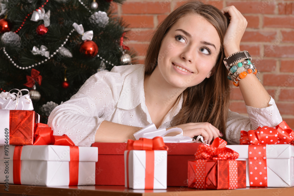 girl with gifts near the Christmas tree girl with gifts near the Christmas tree