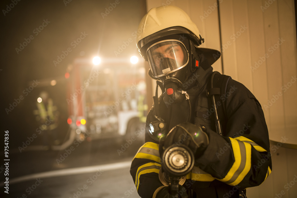 Fototapeta premium Firefighters in action battling the flames