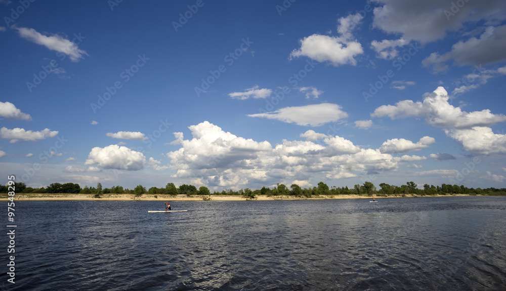 Summer landscape with river and clouds in the sky.