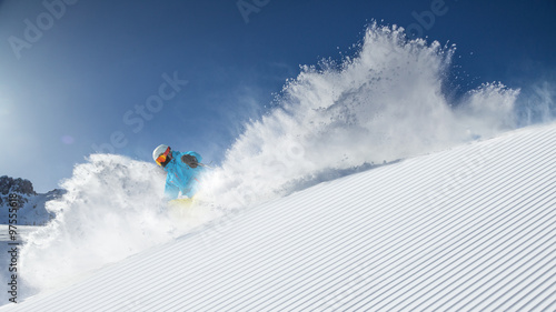Fotografie Skier skiing downhill in high mountains