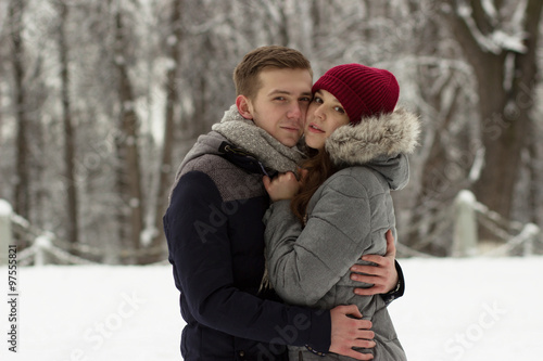 Hugging pair standing in winter park