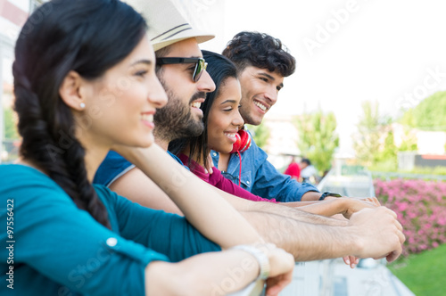 Young friends leaning on railing