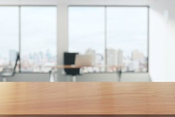 Wooden table in light office with panoramic windows