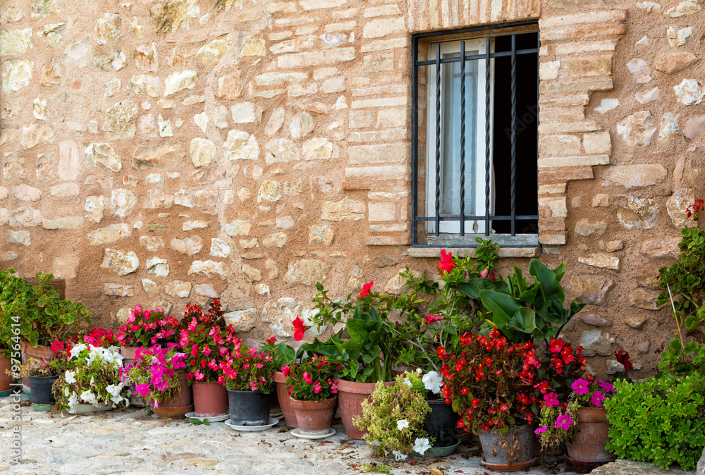 Plants in pots on narrow streets of the ancient city of Spello, Umbria, Italy