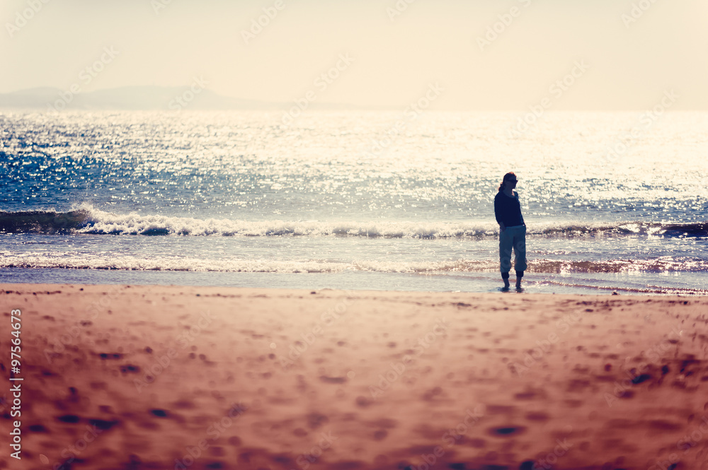 Care free woman taking a walk before sunset on the Essaouira beach. Vacation vitality, healthy living concept Care free woman taking a walk before sunset on the Essaouira beach. Vacation vitality, healthy living concept