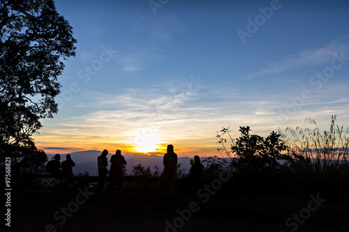 People with trees silhouetted and stunning sunset