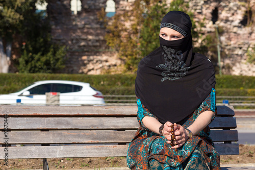 Photography Muslim Style dressed Lady sitting on wooden Bench Sad