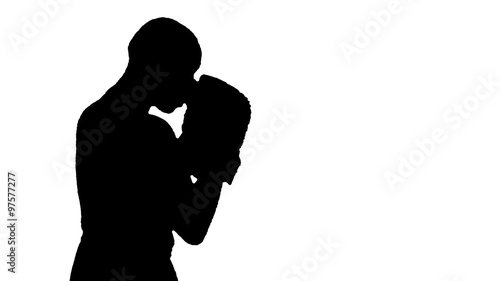 HD silhouette footage of a bald man wearing boxing gloves throwing various punches.