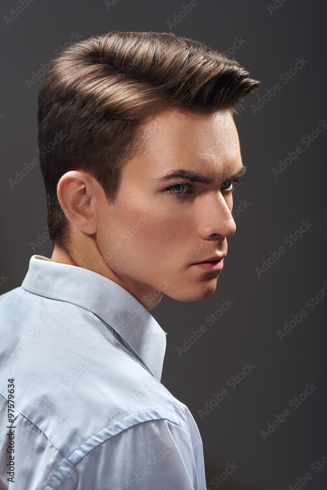 Portrait of handsome young man with fashion haircut on gray background Portrait of handsome young man with fashion haircut on gray background