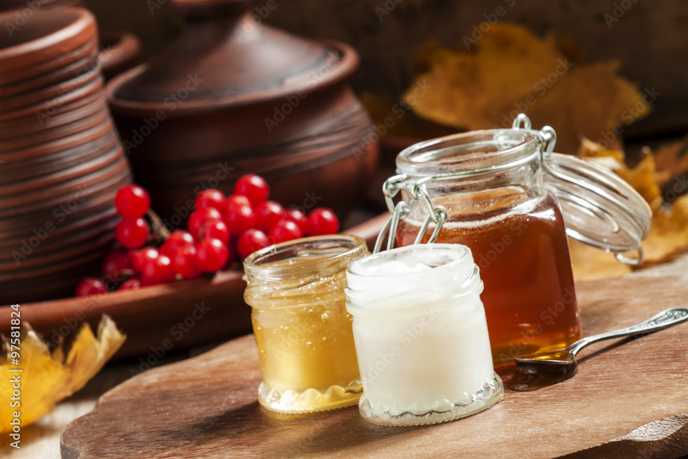 Honey assortment in small jars in the autumn background with row Honey assortment in small jars in the autumn background with row
