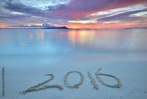 Number 2016 written on a beach during sunset