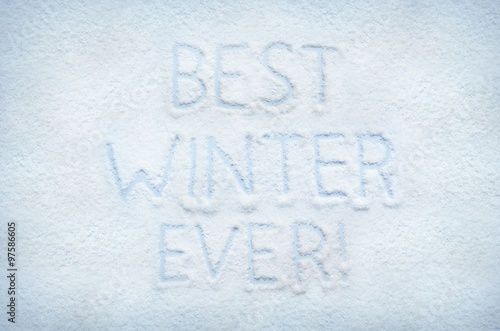 Text BEST WINTER EVER written on snow. Horizontal postcard.