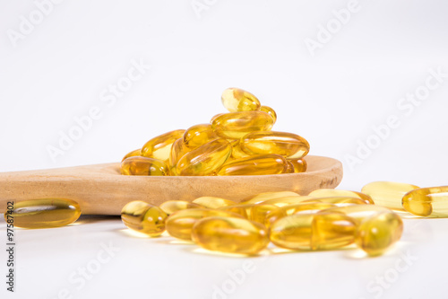 Omega 3 fish oil capsule on wooden spoon