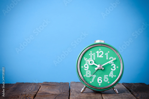 Wallpaper Mural Old retro clock on wooden table with blue background still life with copy space Torontodigital.ca