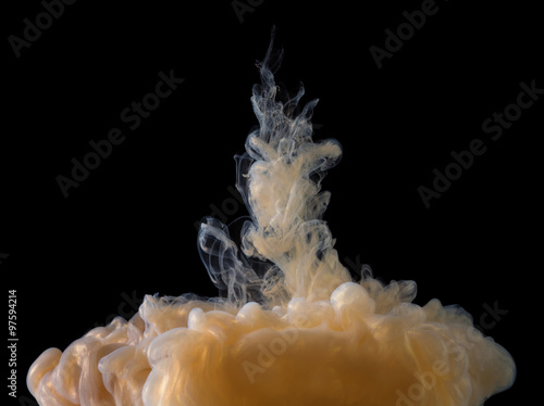 Golden paint cloud with glitter in water isolated on black