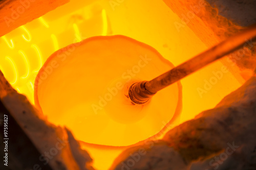 Obraz na plátně Handmade figure of melted glass, a glass blower working molten glass on a rod