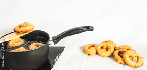 Fresh made doughnuts from boiling hot oil onto baking paper photo