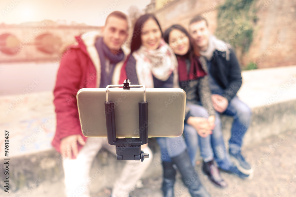 Smiling friends taking selfie outdoor with stick in oldtown centre -  Friendship and tecnology concept - Focus on smartphone - Desatured filter  look Stock Photo | Adobe Stock
